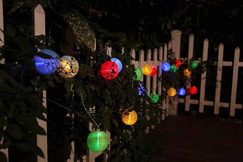 Verwendung von bunten lampion lichterkette am Zaun